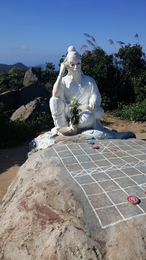 Estatua del pensador frente a juego tradicional vietnamita, Danang, Vietnam, 2015